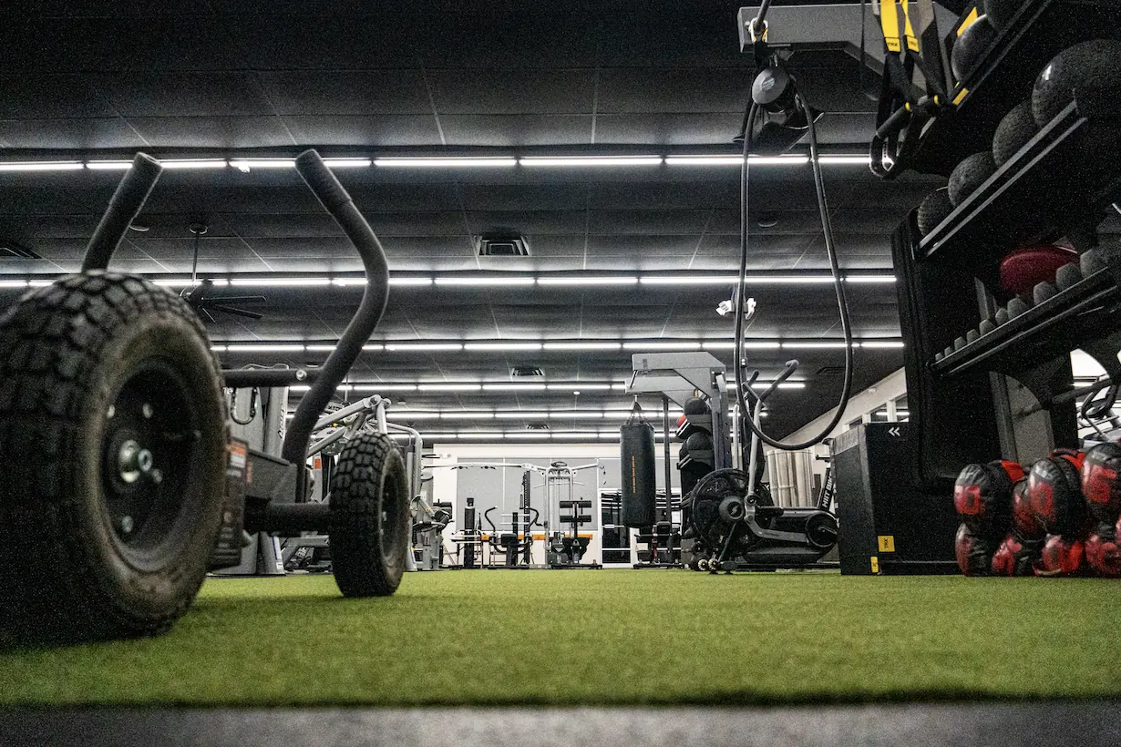 Turf stretching and recovery zone with sled, medicine balls and TRX straps at The Training Room