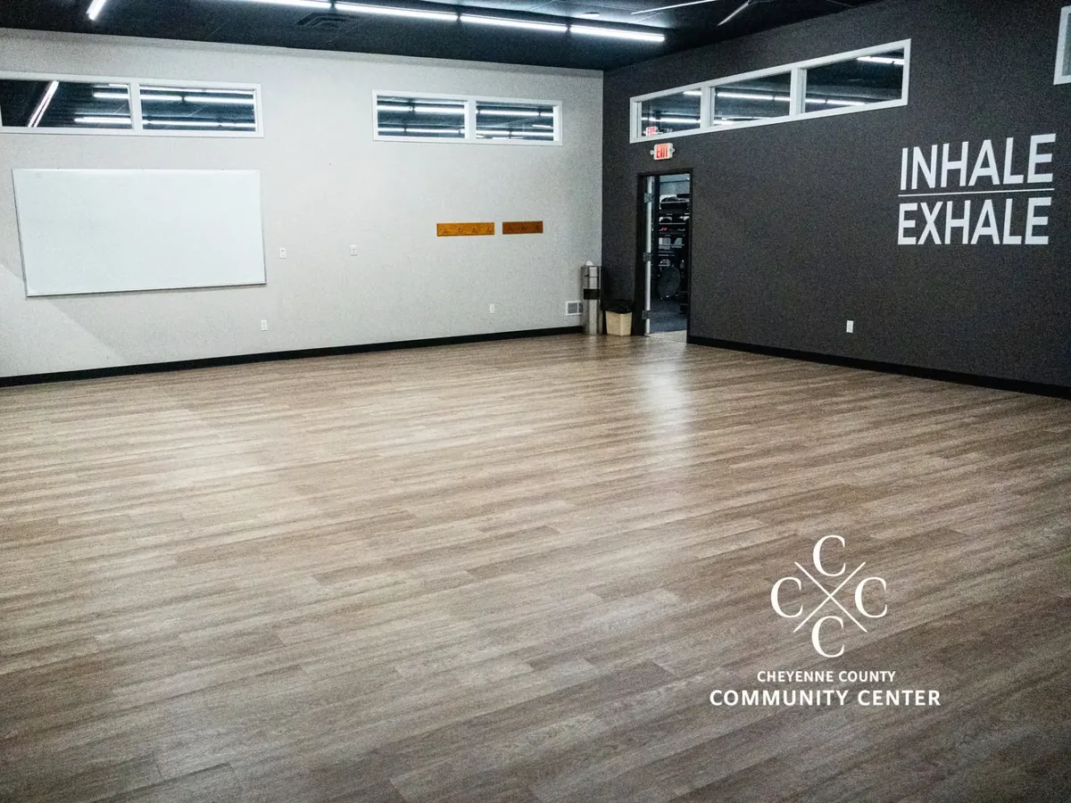 Training Room classroom studio with wood floor, whiteboard and wall lettering at The Center