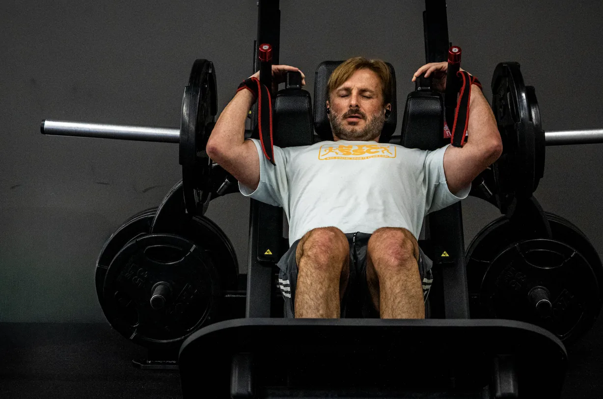 Member training on a plate loaded specialty leg press machine at The Training Room