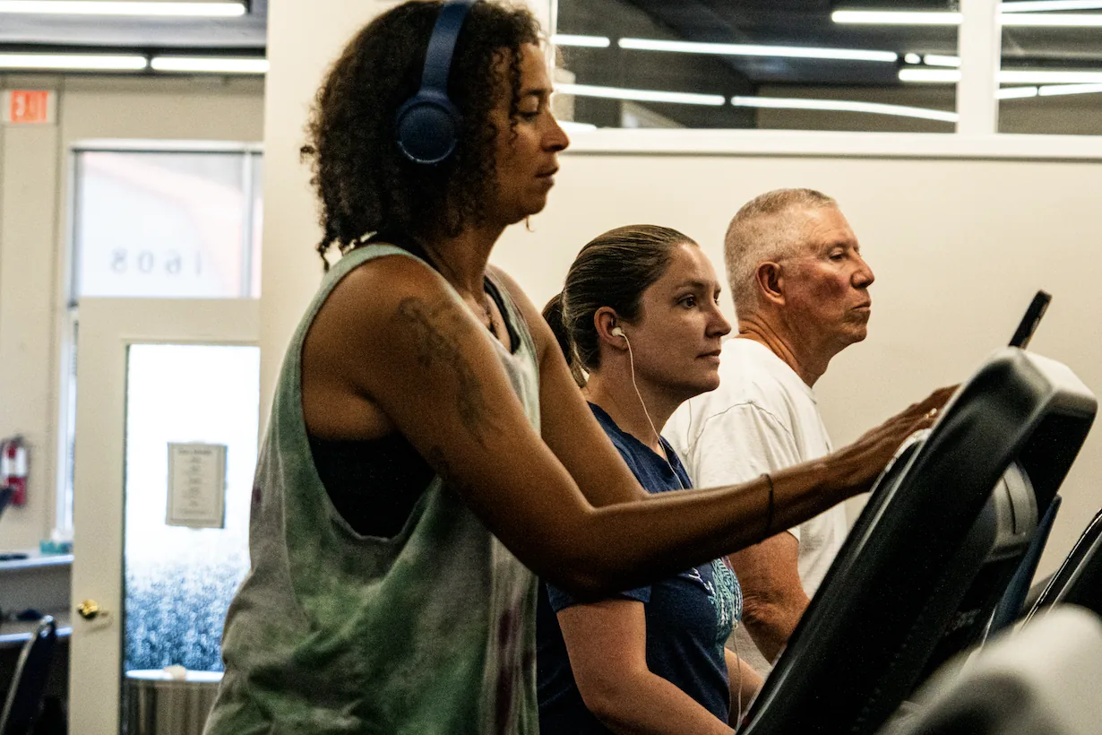 Three members side by side on treadmills in the cardio area at The Training Room