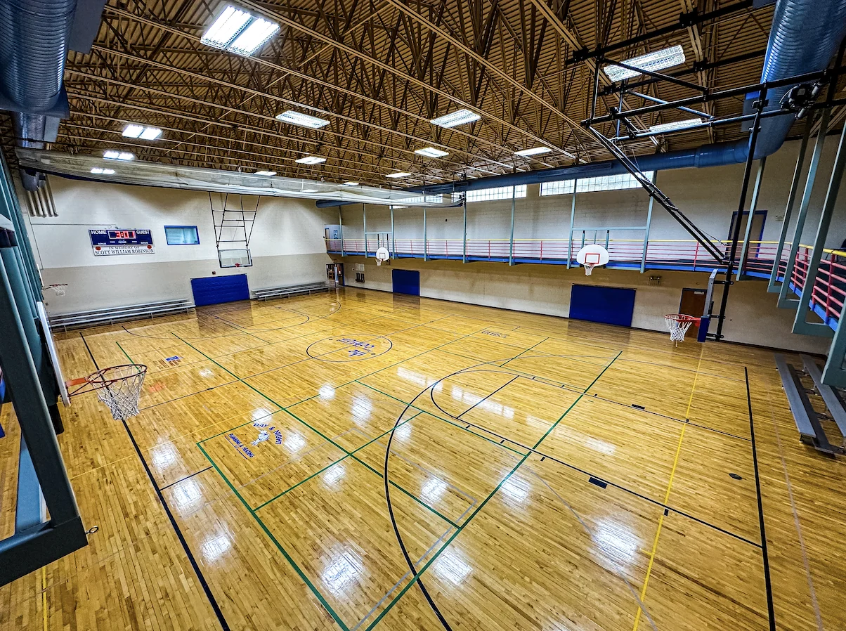 Overhead view of The Center's Main Gym with hardwood courts, basketball hoops and an elevated walking track