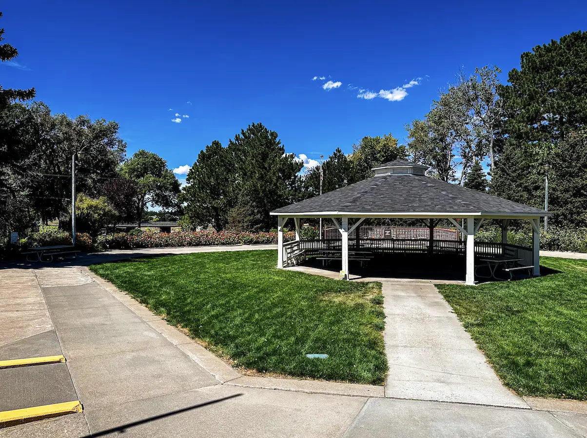 The gazebo at Memorial Gardens surrounded by flower beds and green lawn