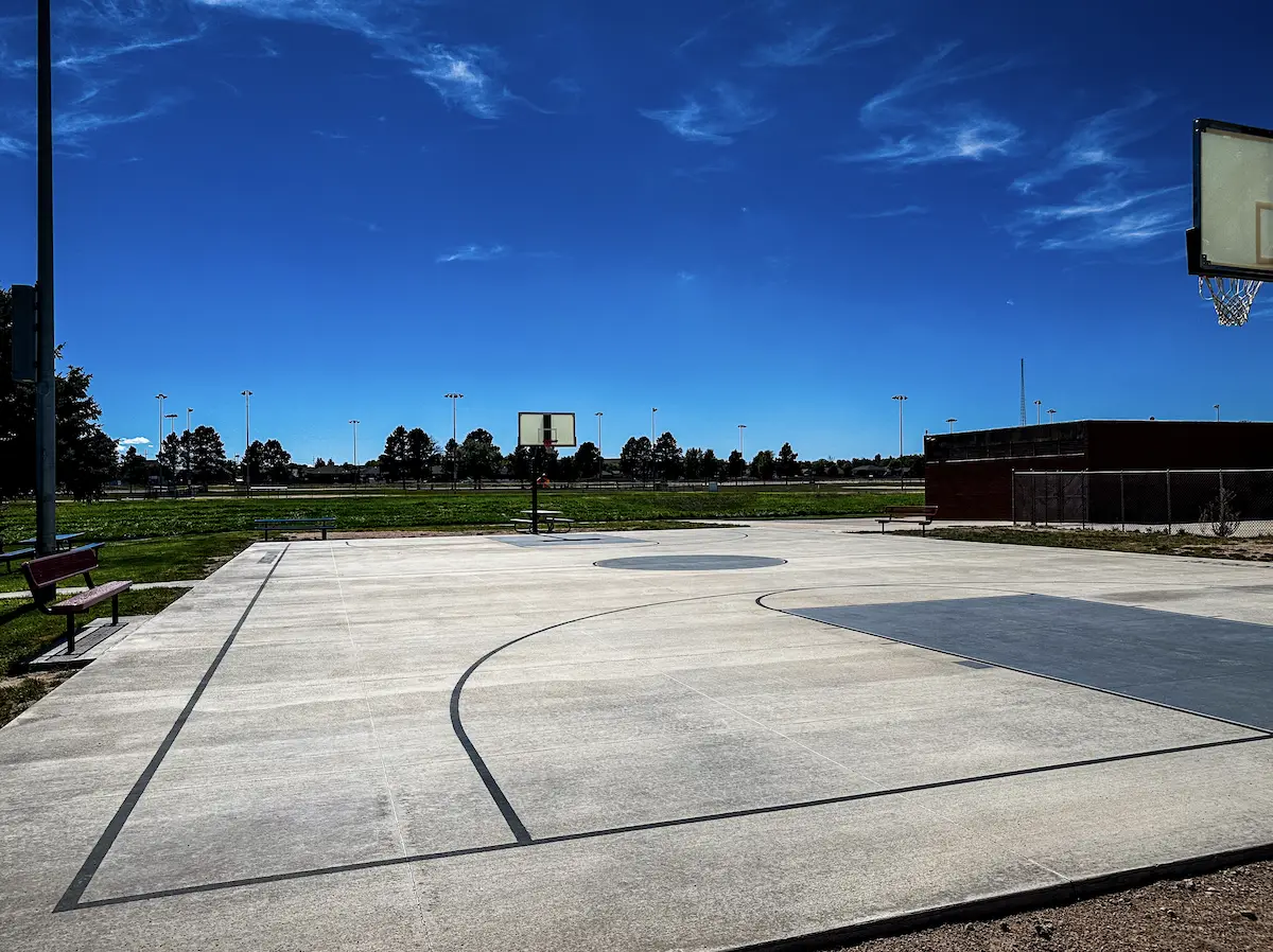 Outdoor concrete basketball court with hoops and painted lines at The Center