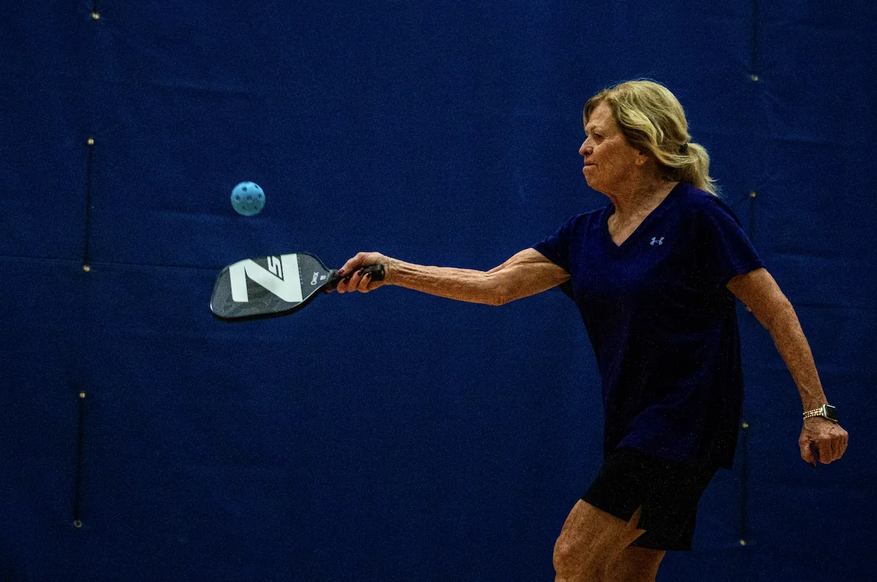Player returning a shot with a paddle during indoor pickleball at The Center