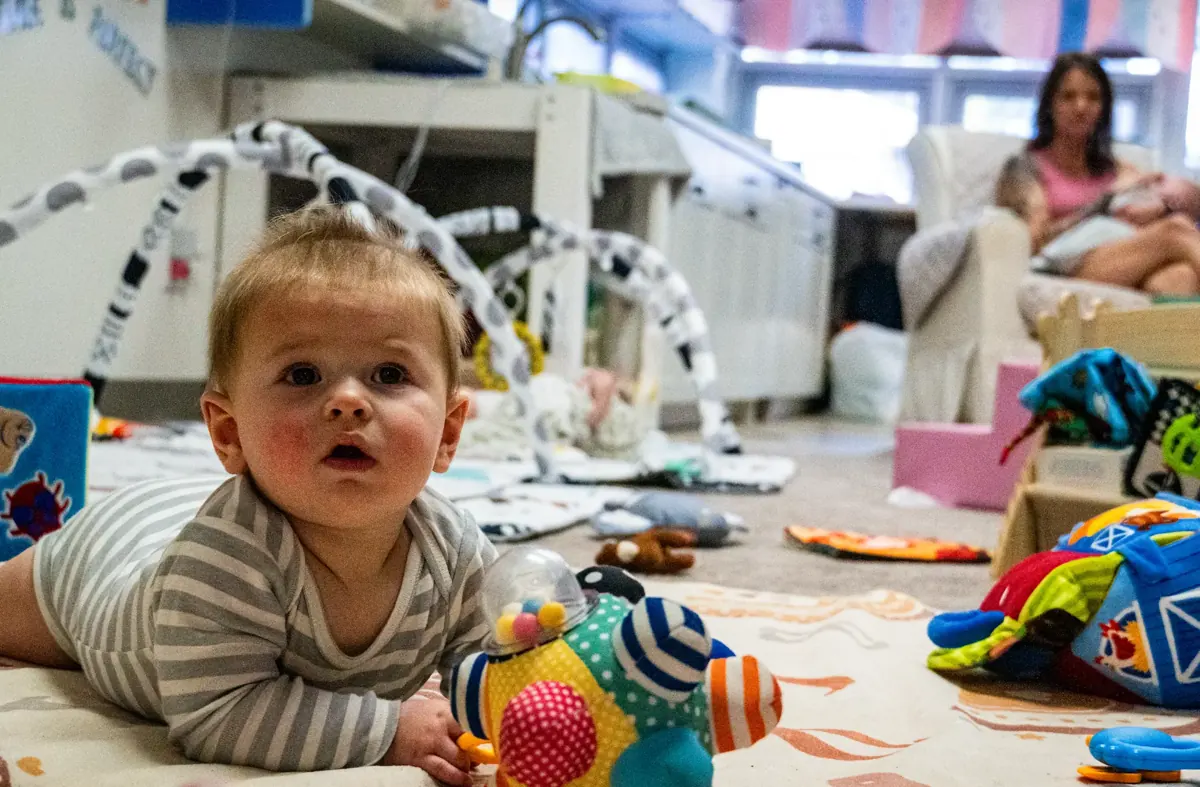 Infant lying on a play mat surrounded by soft toys in the Kids Korner Infant Room