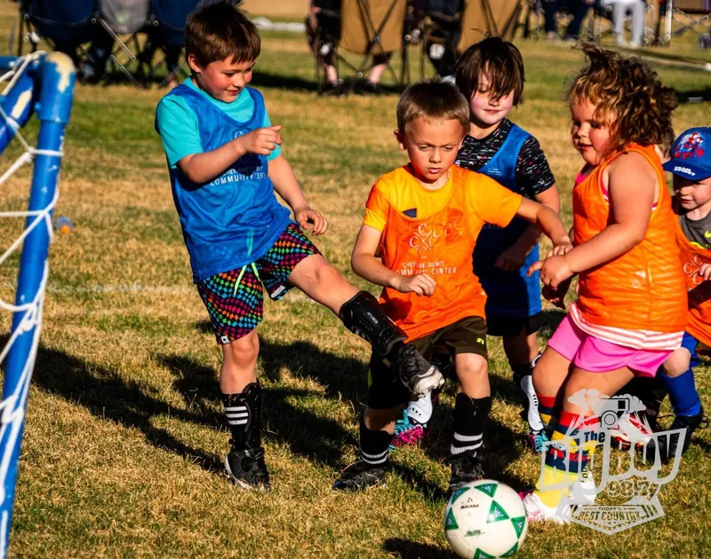 Young players in The Center pinnies battling for the ball near the goal during a youth soccer game in Sidney, Nebraska